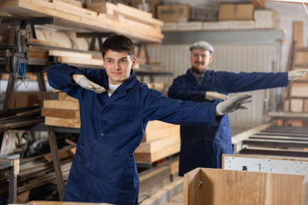 Young men doing exercises in wood workshop