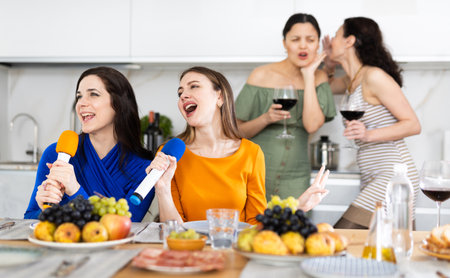 Group of female friends are having fun singing karaoke during feast and gatherings.の写真素材
