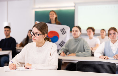 Teacher stands behind students with South Korean flagの写真素材