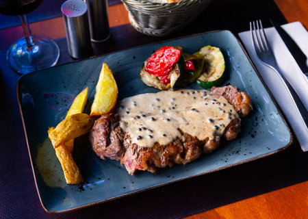 Veal steak with piquant creamy sauce, potatoes and vegetablesの写真素材