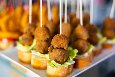 Pincho con croquetas - traditional Spanish snack or bar snack. Ham croquette and piece of baguette