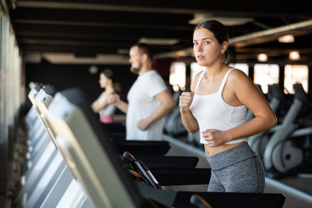 Young woman exercising on treadmill in gymの写真素材