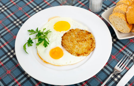 On plate are pancakes with fried eggsの写真素材