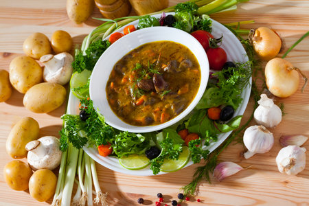 Tasty goulash from chicken hearts with lettuce at plate, fresh vegetablesの写真素材