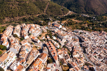 Ojen, small Spanish old town village of white Andalucian houses with green nature around on a sunny dayの写真素材