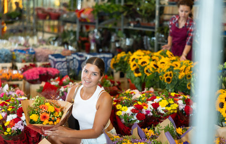 Young woman choosing bouquet of flowersの写真素材