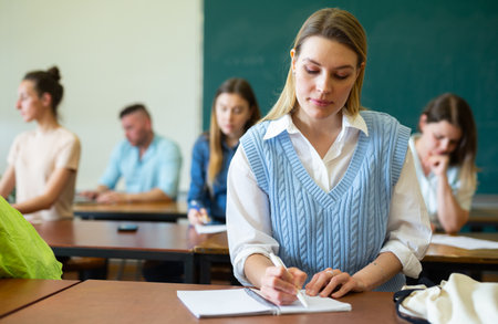 Woman university student writing in classroomの写真素材