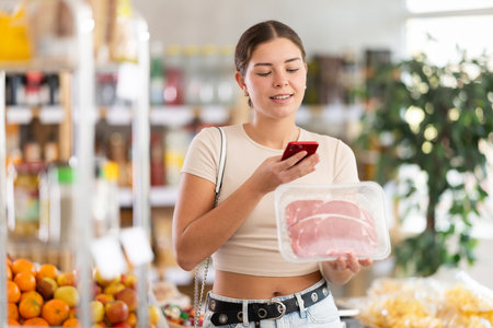 Customer scanning QR-code on raw beef tenderloin package in storeの写真素材