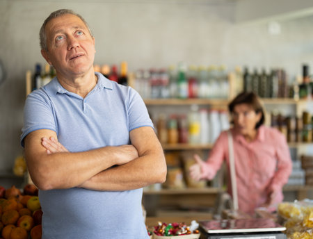 Elderly woman quarrels with man in grocery storeの写真素材