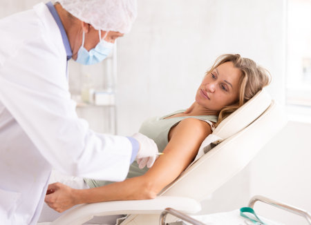 Female patient receiving intramuscular injection from doctor in medical officeの写真素材