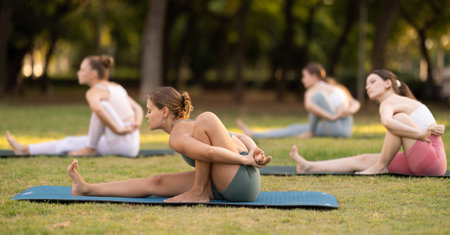 Group of young women doing yoga in parkの写真素材