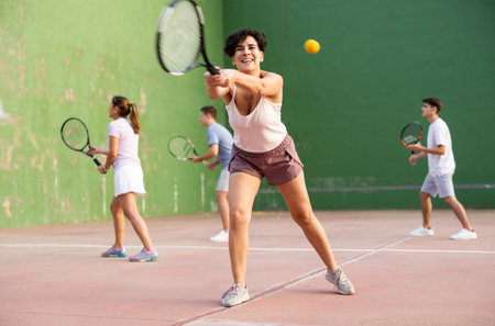 Woman playing tennis with partners at sunny day, healthy lifestyle conceptの写真素材