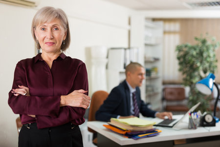 Senior woman clerical worker standing and looking in cameraの写真素材