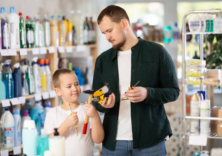 Man and boy choosing tools in storeの写真素材