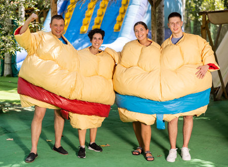 Group photo of smiling men and women wearing funny sumo suitsの写真素材
