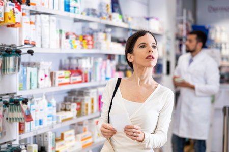 Woman with recipe shopping in pharmacyの写真素材