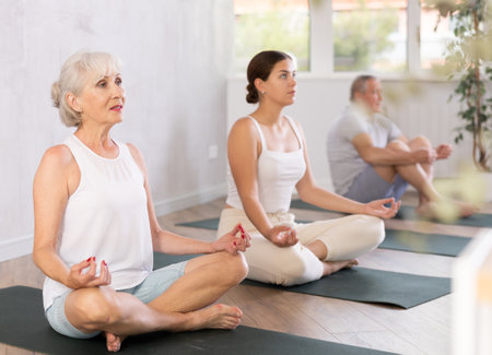 Elderly woman doing yoga on mat in studioの写真素材