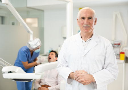 Senior man doctor is standing in dental office, clinicの写真素材
