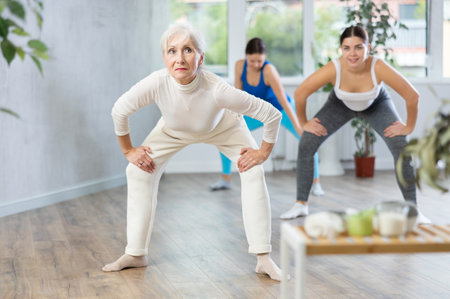 Happy women practicing aerobics in light fitness studioの写真素材