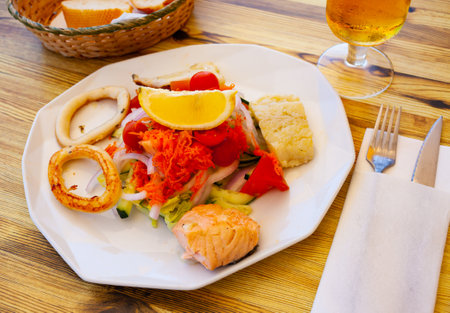 Vegetable salad with grilled squid rings and fishの写真素材