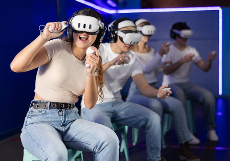 Girl in vr glasses with joysticks playing a video game