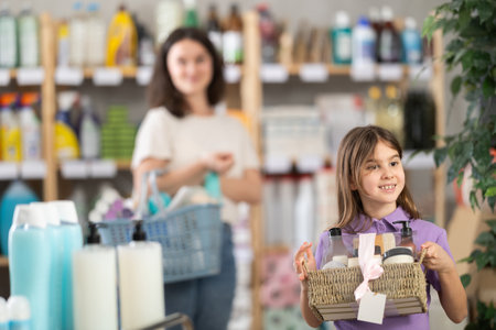 Girl holding a set of care shampoos and shower gels in her handsの写真素材