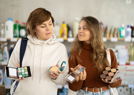 Mother and her adult daughter choose cosmetics together in supermarket