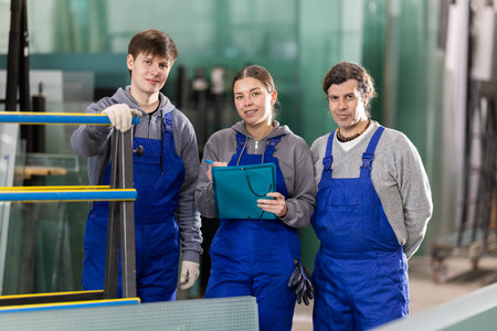 Two men and woman working in glass factory