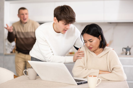 Guy persuades a young girl to stop playing computer games. Upset father in backgroundの写真素材