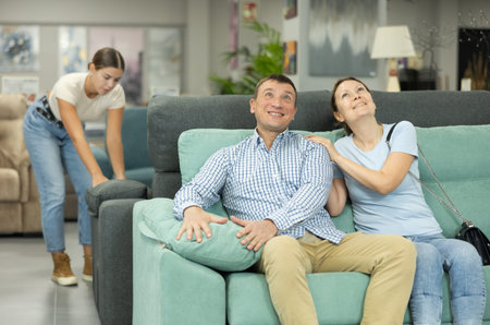Married couple chooses the best new sofa in furniture store