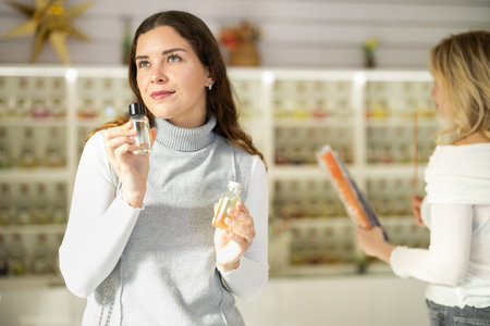 Smiling woman looking perfume for in perfume modern beauty shop
