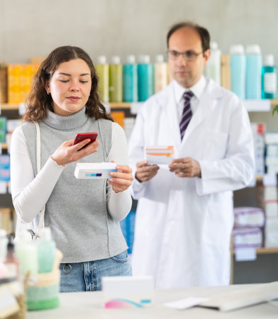 Woman buyer scans ointment qr code with man pharmacistの写真素材