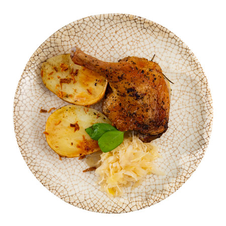 Roast duck leg with potatoes and cabbage on a ceramic plateの写真素材