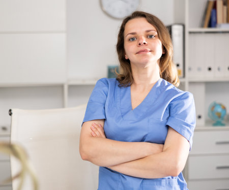 Portrait of therapist woman who is standing on her workplace in clinicの写真素材