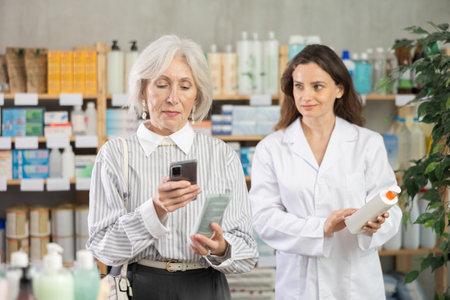 Woman scans cream barcode with pharmacist in backgroundの写真素材