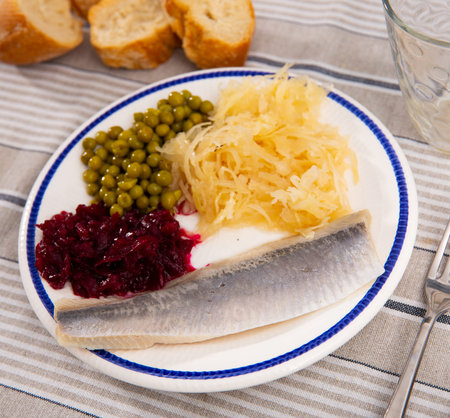 Peas with beets and herring on a plate side viewの写真素材