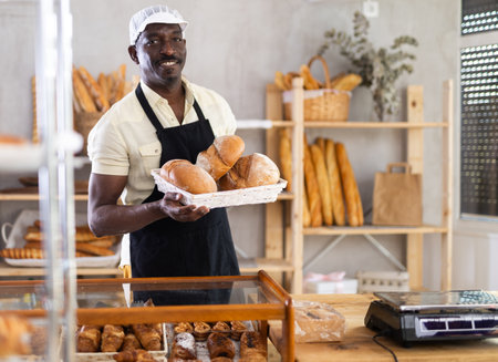 Portrait of joyful man baker with breadの写真素材