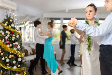 Teenage girl dancing waltz with classmate during Christmas party at collegeの写真素材