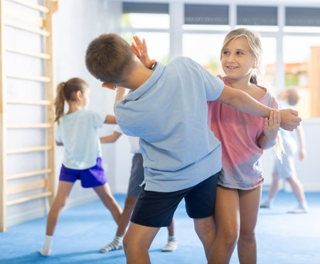 Boys and girls in gym perform basic elements of self-defense system.の写真素材