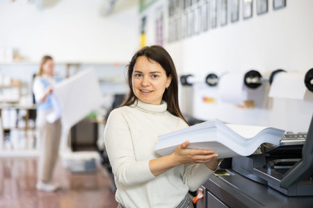 Technician operator changes paper on printer plotter machine