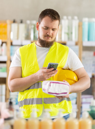 Male builder scans QR code on label using smartphone
