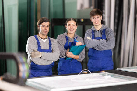 Two men and woman working in glass factoryの写真素材