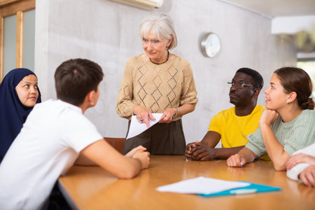 Group of multinational people discussing documents at tableの写真素材