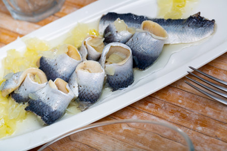 Sliced herring served with onion on wooden tableの写真素材