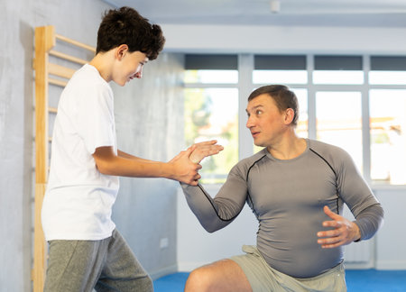 Man and boy teenager training self-defense techniquesの写真素材