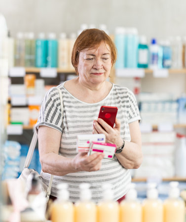 Mature woman scans code on package of pills to check expiration dateの写真素材