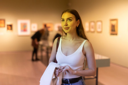 Girl view pictures and icons in museum hall