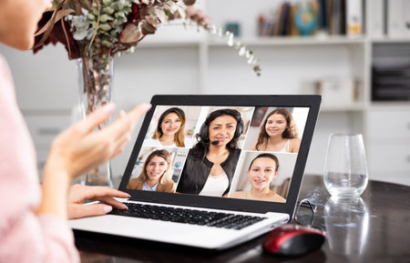 Woman talking with female co-workers via video call