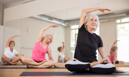 Elderly women practicing yoga trainin the lotus positionの写真素材