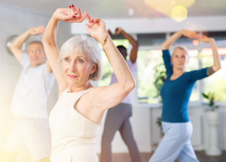 Senior woman dances learn to move energetically to beat of musicの写真素材